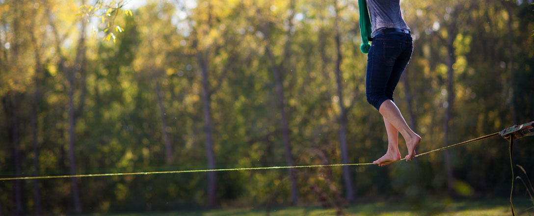 Frau auf Slackline im Park 