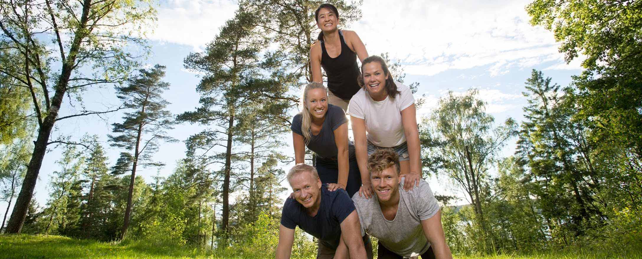 Gruppe an Freunden bildet in Park eine Pyramide