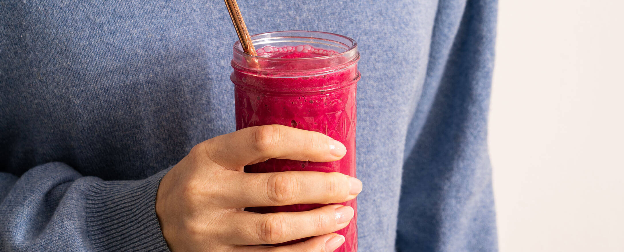 frau haelt smoothie aus roten rueben