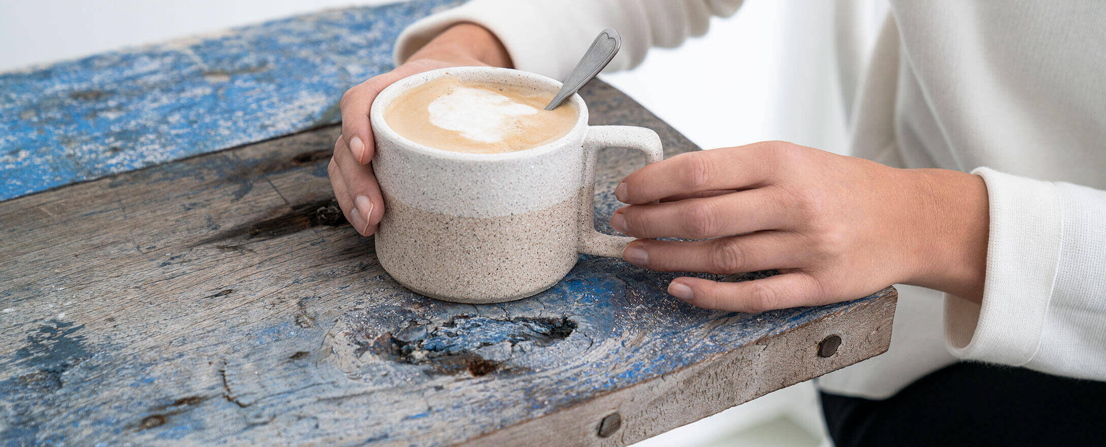 Hände mit Tasse voll Kaffee