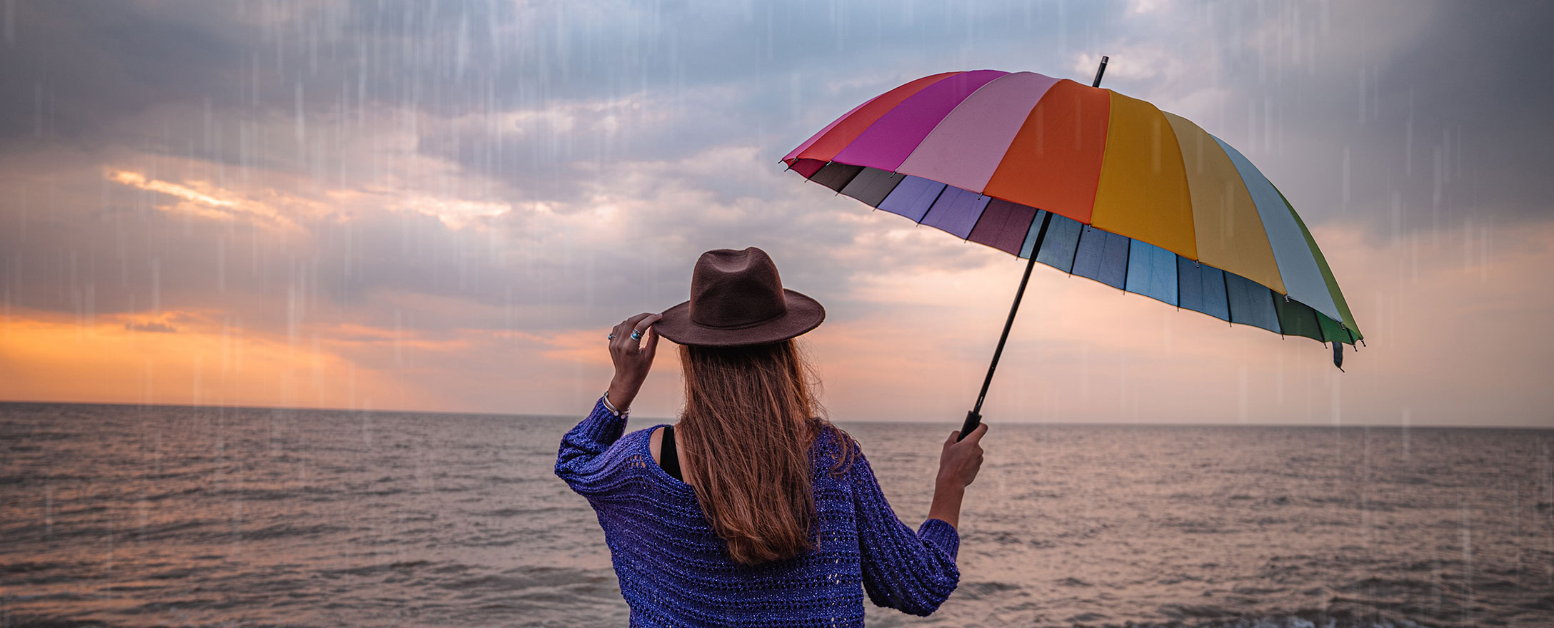 frau mit buntem regenschirm bei regen