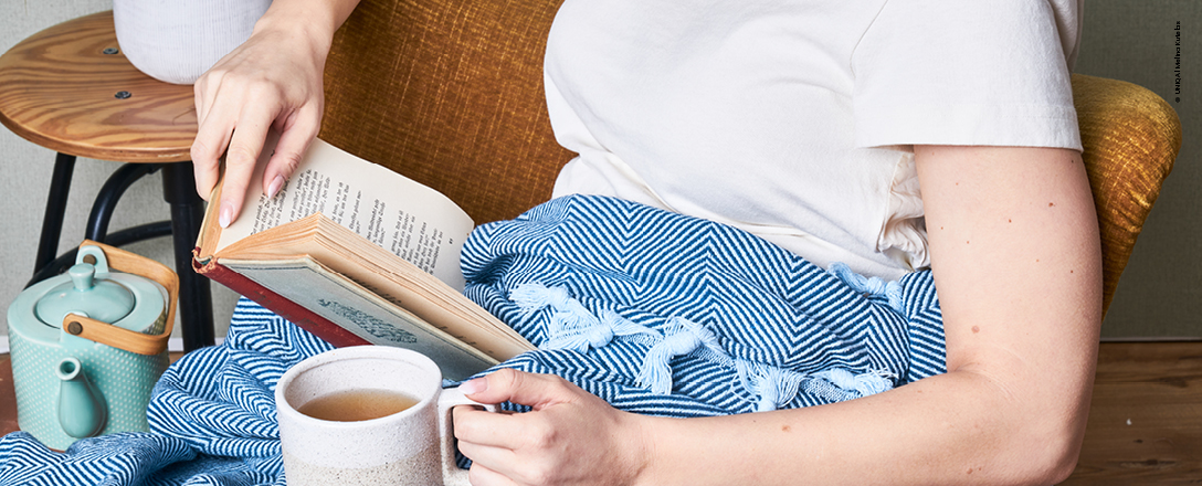 Frau genießt Zeit mit Buch und Tee