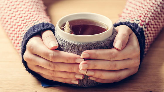 Hände halten eine Tasse Tee